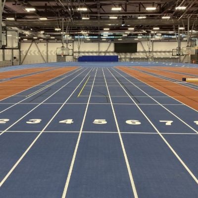 blue indoor track with white lines running vertically from the camera